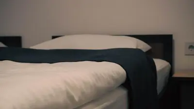 a bed with a black and white blanket on it at IB Oil doo Restoran s prenoćištem in Cazin