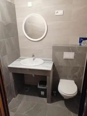 a bathroom with a sink and a toilet and a mirror at Apartmani Vila Alpe in Travnik