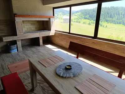 a room with a table and a large window at Apartmani Vila Alpe in Travnik