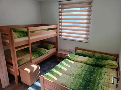 a bedroom with two bunk beds and a window at Apartmani Vila Alpe in Travnik