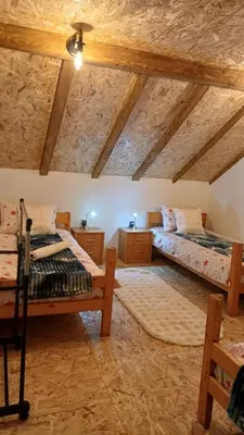 two beds in a room with wooden ceilings at Kuća za odmor Kupreška Čarolija in Kupres