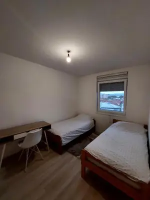 a bedroom with two beds and a desk and a window at Vista Bihać in Bihać