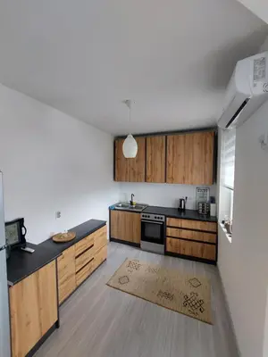 a kitchen with wooden cabinets and black counter tops at Vista Bihać in Bihać
