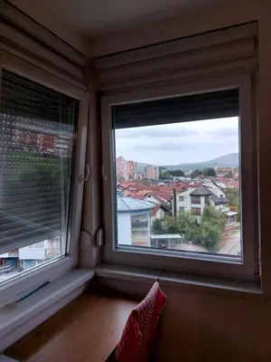 a room with two windows with a view of a city at Vista Bihać in Bihać
