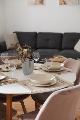 a dining room table with plates and wine glasses at City Central Apartment - Top location in Banja Luka
