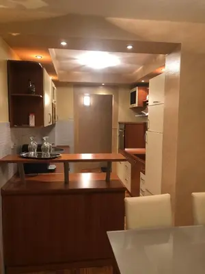 a kitchen with a wooden table in a room at Apartman Mokusnice Zenica in Zenica