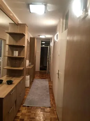 a bathroom with a hallway with a sink and a toilet at Apartman Mokusnice Zenica in Zenica