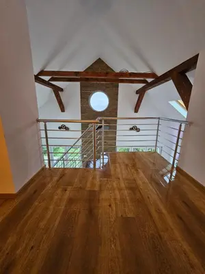 an attic room with a wooden floor and a window at Skylight suite apartment in Tuzla