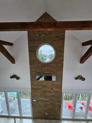 a room with a round window and a brick wall at Skylight suite apartment in Tuzla