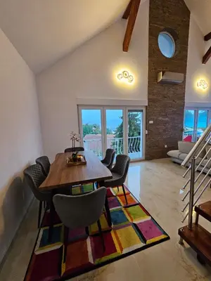 a dining room with a wooden table and chairs at Skylight suite apartment in Tuzla