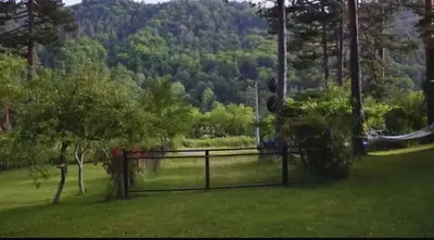 a fence in a field with a mountain in the background at Vila Nature in Zavidovići