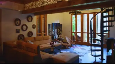 a living room with a couch and a spiral staircase at Vila Nature in Zavidovići