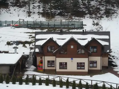 a house in the snow with a train in the background at Motel Luka in Deževice