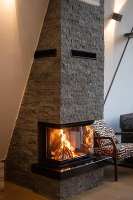 a fireplace in a living room with a brick wall at Vila Hill Rest in Visoko