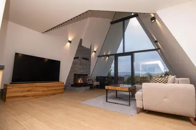 a living room with a large flat screen tv and a fireplace at Vila Hill Rest in Visoko