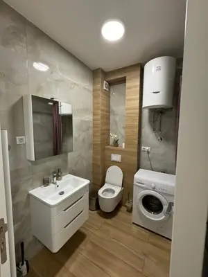 a bathroom with a toilet and a sink and a washing machine at Apartman Blanka in Banja Luka