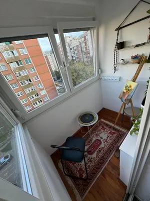 a small room with a chair and two windows at Stan na dan in Zenica