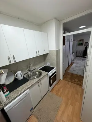 a kitchen with white cabinets and a sink at Stan na dan in Zenica