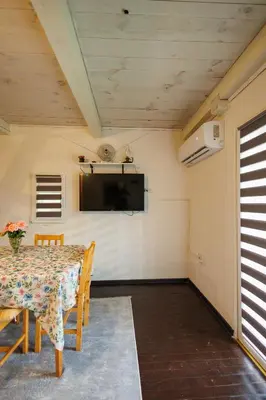 a dining room with a table and a tv on the wall at Studio apartman Farah in Bihać