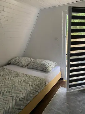 a bed in a room next to a staircase at Studio apartman Farah in Bihać