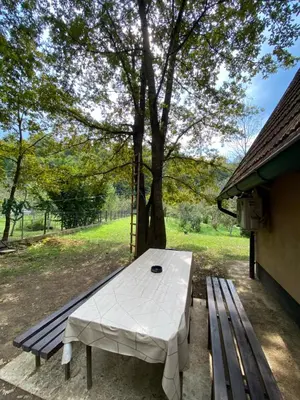 a picnic table and a bench next to a tree at Studio apartman Farah in Bihać