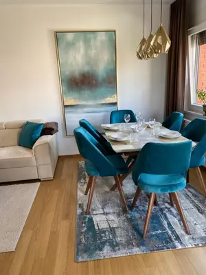 a dining room with a table and blue chairs at RED home in Banja Luka