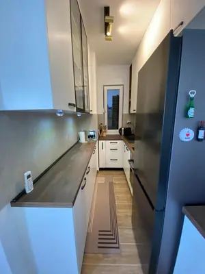 a kitchen with a stainless steel refrigerator and white cabinets at RED home in Banja Luka