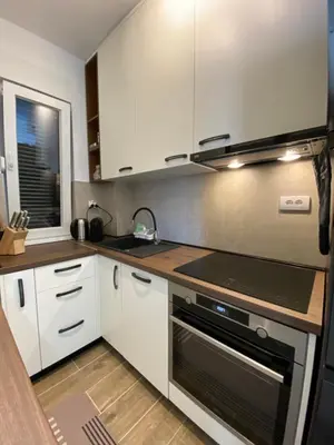 a kitchen with white cabinets and a stove top oven at RED home in Banja Luka