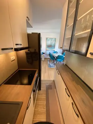 a kitchen with white cabinets and a dining room at RED home in Banja Luka