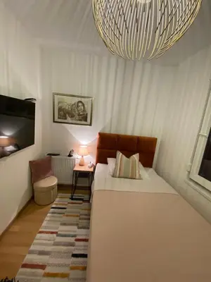 a bedroom with a large bed and a chandelier at RED home in Banja Luka