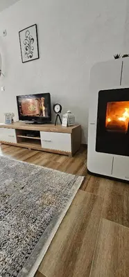 a living room with a television and a fireplace at Apartman Deny in Sanski most