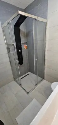 a shower with a glass door in a bathroom at Apartman Deny in Sanski most
