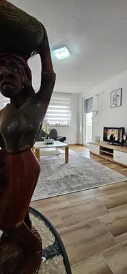 a living room with a statue of a woman at Apartman Deny in Sanski most