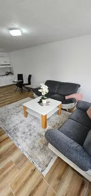 a living room with a couch and a table at Apartman Deny in Sanski most