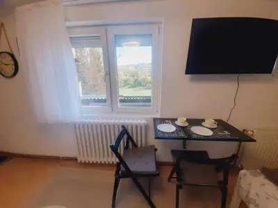 a room with a table and a television and a chair at Studio Apartman in Banja Luka