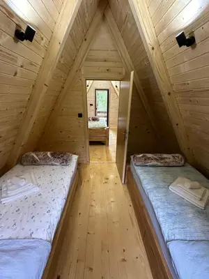 a bedroom with two beds in a wooden attic at Plivska vila 1 in Jajce