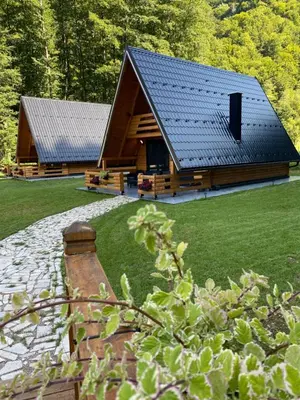 a large wooden cabin with a black roof at Plivska vila 1 in Jajce