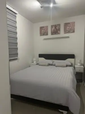 a white bedroom with a bed and a ceiling fan at Premium in Prijedor