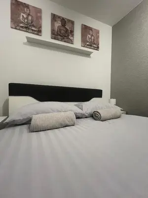 a white bed with two pillows on top of it at Premium in Prijedor
