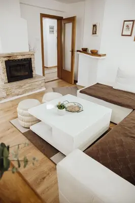 a living room with a white coffee table and a fireplace at Ice Queen Vlasic in Šišava
