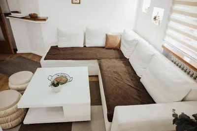 a living room with a white couch and a table at Ice Queen Vlasic in Šišava