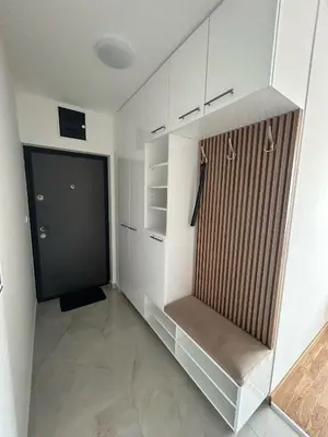 a walk in closet with white cabinets and a door at Apartmani Kastel 1 in Banja Luka