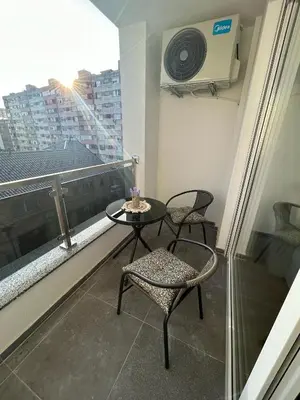 a balcony with two chairs and a table and a window at Apartmani Kastel 1 in Banja Luka