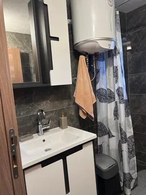 a bathroom with a sink and a shower curtain at Vikendica Brljak in Gostilj