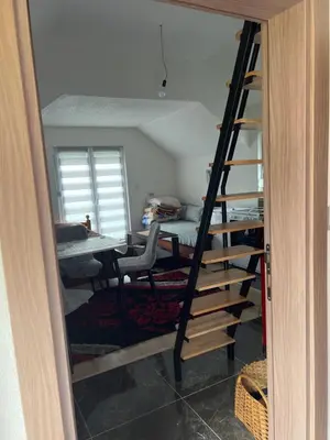 a ladder leading to a room with a desk and a table at Vikendica Brljak in Gostilj