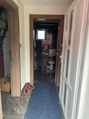 a hallway with a bathroom with a toilet and a door at Vikendica Brljak in Gostilj