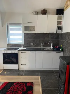 a kitchen with white cabinets and a sink at Vikendica Brljak in Gostilj