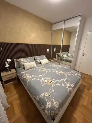 a bedroom with a bed and a large mirror at Apartman Greenville Banja Luka in Banja Luka