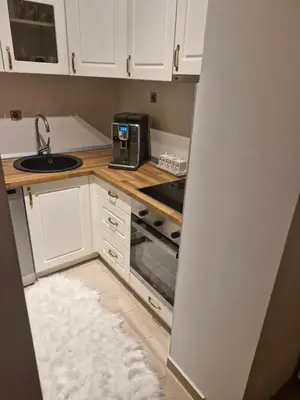 a kitchen with white cabinets and a sink and a microwave at Apartman Greenville Banja Luka in Banja Luka