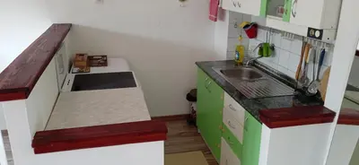 a small kitchen with green cabinets and a sink at Jukan Apartman in Tuzla